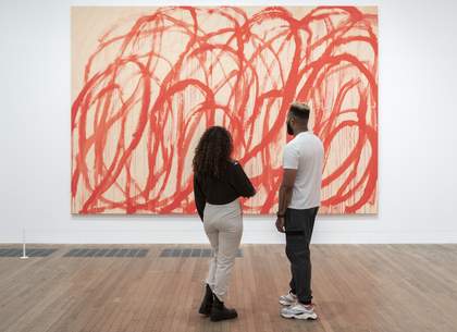 A man and a woman looking at an abstract painting